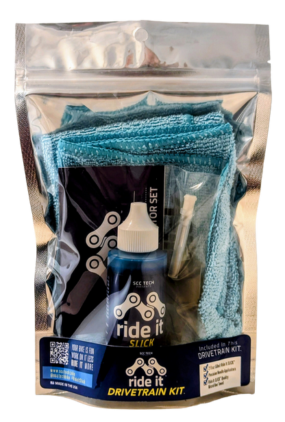 Ride It Drivetrain Kit by SCC Tech, featuring a complete bike maintenance solution. The packaging displays the Ride It brand logo and includes products like Ride It Slick, Ride It Clean, Ride It Smooth, and Ride It Flow. The kit contains 2 fl oz (59 ml) bottle of Ride It Slick drivetrain treatment, precision needle applicators, and a microfiber towel. The label highlights the kit’s focus on enhancing bike performance and protection, with bold text encouraging less time working on it and more time riding it 